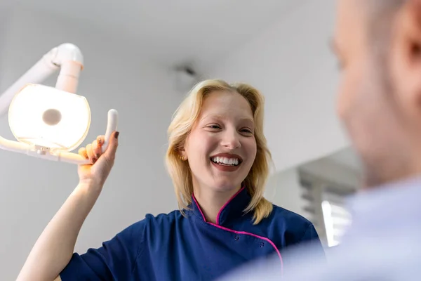 Genç dişçi işe başlamadan önce projektörleri ayarlar