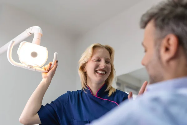 Genç dişçi işe başlamadan önce projektörleri ayarlar