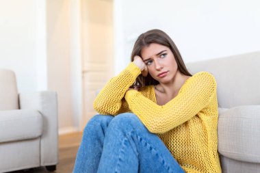 Evdeki kanepede oturan endişeli kadın. Hayal kırıklığına uğramış kadın mutsuz hissediyor, özel hayatındaki sorunlar, erkek arkadaşından ayrılması ve beklenmedik hamilelik kavramı.