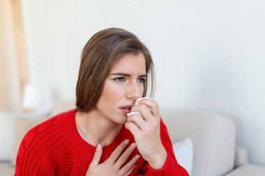 Hasta, çaresiz kadın grip olmuş. Rhinitis, soğuk, hastalık, alerji konsepti. Güzel hasta bir kadının burnu akıyor, burnu mendille sürtüyor. Hapşıran kadın. Esmer mendilin içinde hapşırıyor.