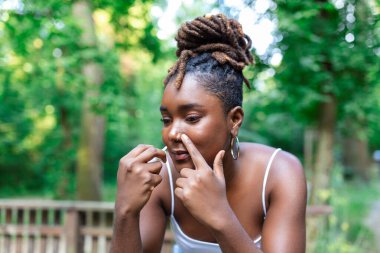 Kadın grip olmuş ve kendine yardım etmek için burun spreyi kullanıyor. Burun spreyi kullanan bir kadın. Soğuk algınlığına iyi gelir. Burnu akan bir kadının hastalığından. Kadın burun spreyi sıkar.