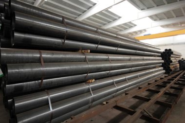 Fabrikanın içindeki metal boru yığını.
