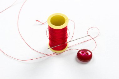 İki delikli düğme. İnce kırmızı iplik.