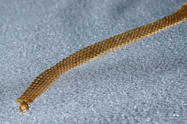 Parlak arkaplanda altın bilezik