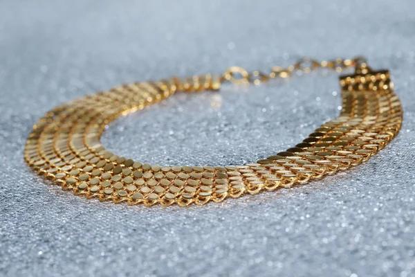 Parlak arkaplanda altın bilezik