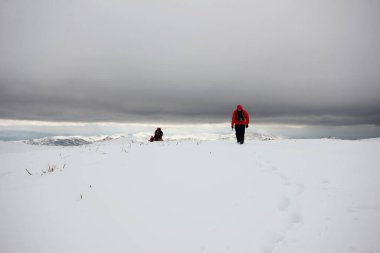Dağlarda karla kaplı bir grup dağcı yürüyor.