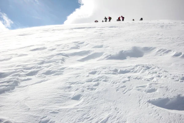 山の雪に覆われた山を歩く登山者のグループ — ストック写真