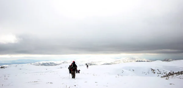 山の雪に覆われた山を歩く登山者のグループ — ストック写真