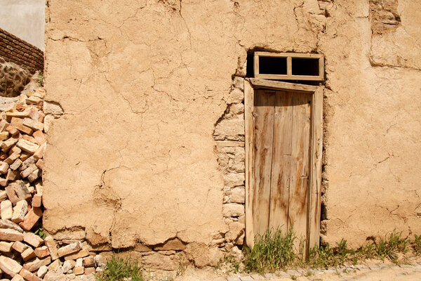 Abandoned old adobe house and wooden door