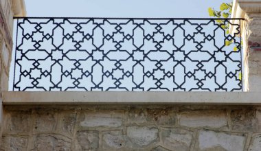 Taş duvar ve işlenmiş demir.