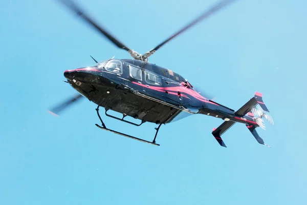 Black commercial helicopter in flight