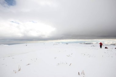 Dağlarda karla kaplı bir grup dağcı yürüyor.