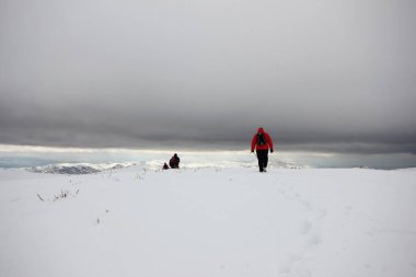 Dağlarda karla kaplı bir grup dağcı yürüyor.