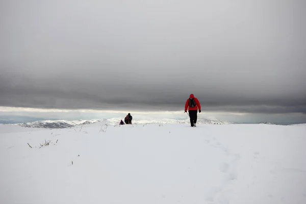 一队登山者走过被雪覆盖的群山 — 图库照片