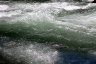 Dalgalarla akan hızlı bir nehirde suyun yüzeyine yakın çekim