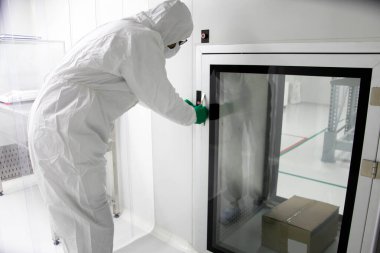 Biyolojik tehlike elbisesi giyen bir sağlık görevlisi.