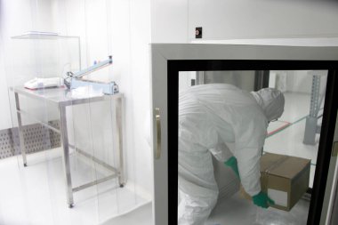 Biyolojik tehlike elbisesi giyen bir sağlık görevlisi.