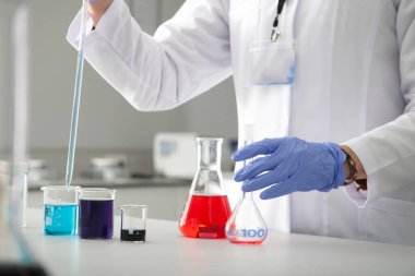 Modern bir laboratuarda plastik tüplerle araştırma yapan bir doktor..