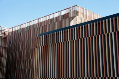 Dikey kaplama ve geometrik tasarımı olan modern mimari.