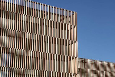 Dikey kaplama ve geometrik tasarımı olan modern mimari.