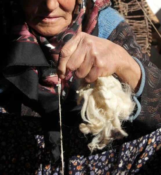 Old woman spinning wool — Stock Photo, Image