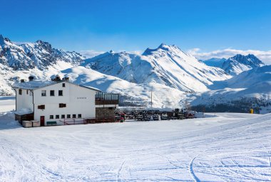 Livigno, İtalya - 8 Ocak 2019: Kuzeydoğu İtalya 'daki Dolomitlerin güzel kış manzarası ve kayak pistinin tepesindeki geleneksel restoran