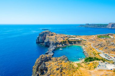 Rodos, Yunanistan - 14 Ağustos 2019: Rhodes Adası 'ndaki dağlık, kayalık plajlı ve yat marinalı güzel St. Paul Körfezi' nin batısı