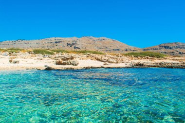 Rhodes Adası 'ndaki dağ ve kayalık plajlı güzel körfezin manzarası