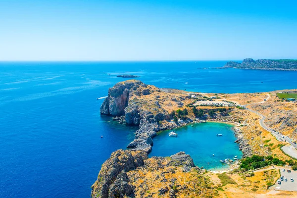 Rhodes Adası 'ndaki güzel St. Paul Körfezi' nin gün batımı manzarası. Dağ, kayalık plaj ve yat marinası.