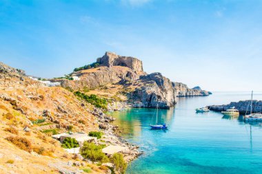 Rodos, Yunanistan - 14 Ağustos 2019: Rhodes Adası 'ndaki dağlık, kayalık plajlı ve yat marinalı güzel St. Paul Körfezi' nin batısı