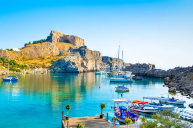 Rodos, Yunanistan - 14 Ağustos 2019: Rhodes Adası 'ndaki dağlık, kayalık plajlı ve yat marinalı güzel St. Paul Körfezi' nin batısı