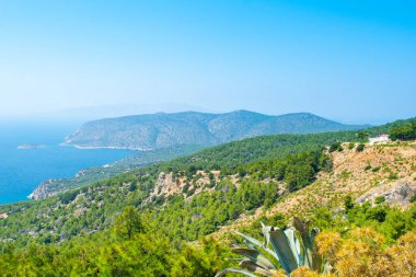 Rodos adasının yeşil kıyılarının güzel Akdeniz manzarası ve tepenin üstünde küçük geleneksel bir şapel, Yunanistan