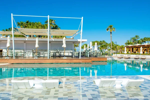 塞浦路斯利马索尔 2021年5月19日 豪华现代酒店的游泳池区 在棕榈树和热带植物树阴下有日光浴床 — 图库照片