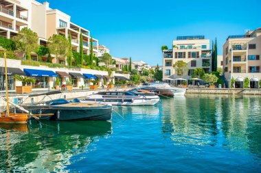 Tivat, Karadağ - 28 Haziran 2021: Porto Karadağ 'daki yat marinasının deniz kenarındaki konutları ve güzel gezinti alanlarıyla gün batımı manzarası