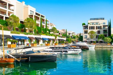 Tivat, Karadağ - 28 Haziran 2021: Porto Karadağ 'daki yat marinasının deniz kenarındaki konutları ve güzel gezinti alanlarıyla gün batımı manzarası