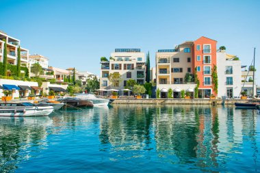 Tivat, Karadağ - 28 Haziran 2021: Porto Karadağ 'daki yat marinasının deniz kenarındaki konutları ve güzel gezinti alanlarıyla gün batımı manzarası