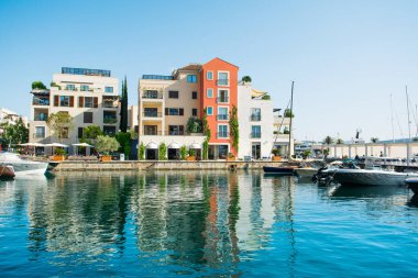Tivat, Karadağ - 28 Haziran 2021: Porto Karadağ 'daki yat marinasının deniz kenarındaki konutları ve güzel gezinti alanlarıyla gün batımı manzarası