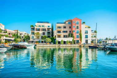 Tivat, Karadağ - 28 Haziran 2021: Porto Karadağ 'daki yat marinasının deniz kenarındaki konutları ve güzel gezinti alanlarıyla gün batımı manzarası