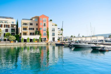 Tivat, Karadağ - 28 Haziran 2021: Porto Karadağ 'daki yat marinasının deniz kenarındaki konutları ve güzel gezinti alanlarıyla gün batımı manzarası