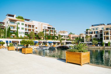 Tivat, Karadağ - 28 Haziran 2021: Porto Karadağ 'daki yat marinasının deniz kenarındaki konutları ve güzel gezinti alanlarıyla gün batımı manzarası