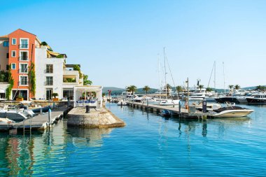 Tivat, Karadağ - 28 Haziran 2021: Porto Karadağ 'daki yat marinasının deniz kenarındaki konutları ve güzel gezinti alanlarıyla gün batımı manzarası