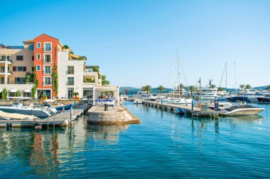 Tivat, Karadağ - 28 Haziran 2021: Porto Karadağ 'daki yat marinasının deniz kenarındaki konutları ve güzel gezinti alanlarıyla gün batımı manzarası