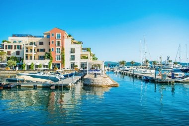 Tivat, Karadağ - 28 Haziran 2021: Porto Karadağ 'daki yat marinasının deniz kenarındaki konutları ve güzel gezinti alanlarıyla gün batımı manzarası