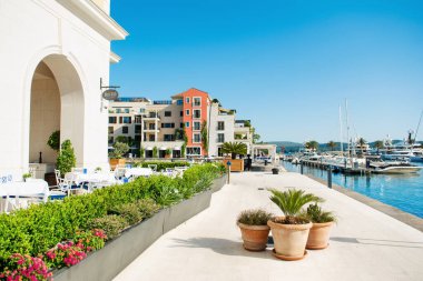 Tivat, Karadağ - 28 Haziran 2021: Porto Karadağ 'daki yat marinasının deniz kenarındaki konutları ve güzel gezinti alanlarıyla gün batımı manzarası