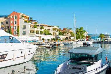 Tivat, Karadağ - 28 Haziran 2021: Porto Karadağ 'daki yat marinasının deniz kenarındaki konutları ve güzel gezinti alanlarıyla gün batımı manzarası