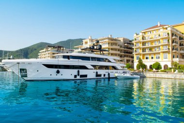 Tivat, Karadağ - 28 Haziran 2021: Porto Karadağ 'daki yat marinasının deniz kenarındaki konutları ve güzel gezinti alanlarıyla gün batımı manzarası