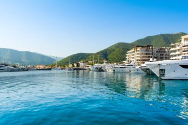 Tivat, Karadağ - 28 Haziran 2021: Porto Karadağ 'daki yat marinasının deniz kenarındaki konutları ve güzel gezinti alanlarıyla gün batımı manzarası