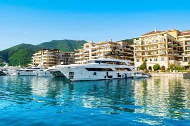 Tivat, Karadağ - 28 Haziran 2021: Porto Karadağ 'daki yat marinasının deniz kenarındaki konutları ve güzel gezinti alanlarıyla gün batımı manzarası