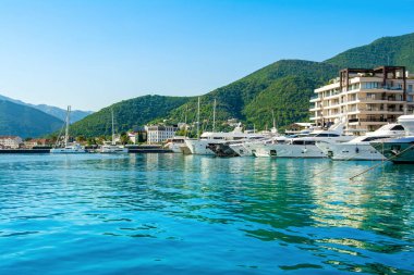 Tivat, Karadağ - 28 Haziran 2021: Porto Karadağ 'daki yat marinasının deniz kenarındaki konutları ve güzel gezinti alanlarıyla gün batımı manzarası