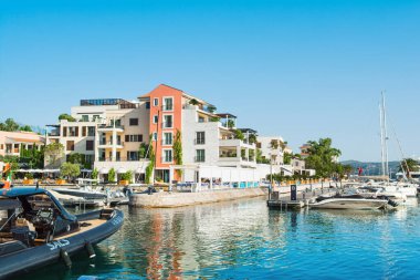 Tivat, Karadağ - 28 Haziran 2021: Porto Karadağ 'daki yat marinasının deniz kenarındaki konutları ve güzel gezinti alanlarıyla gün batımı manzarası